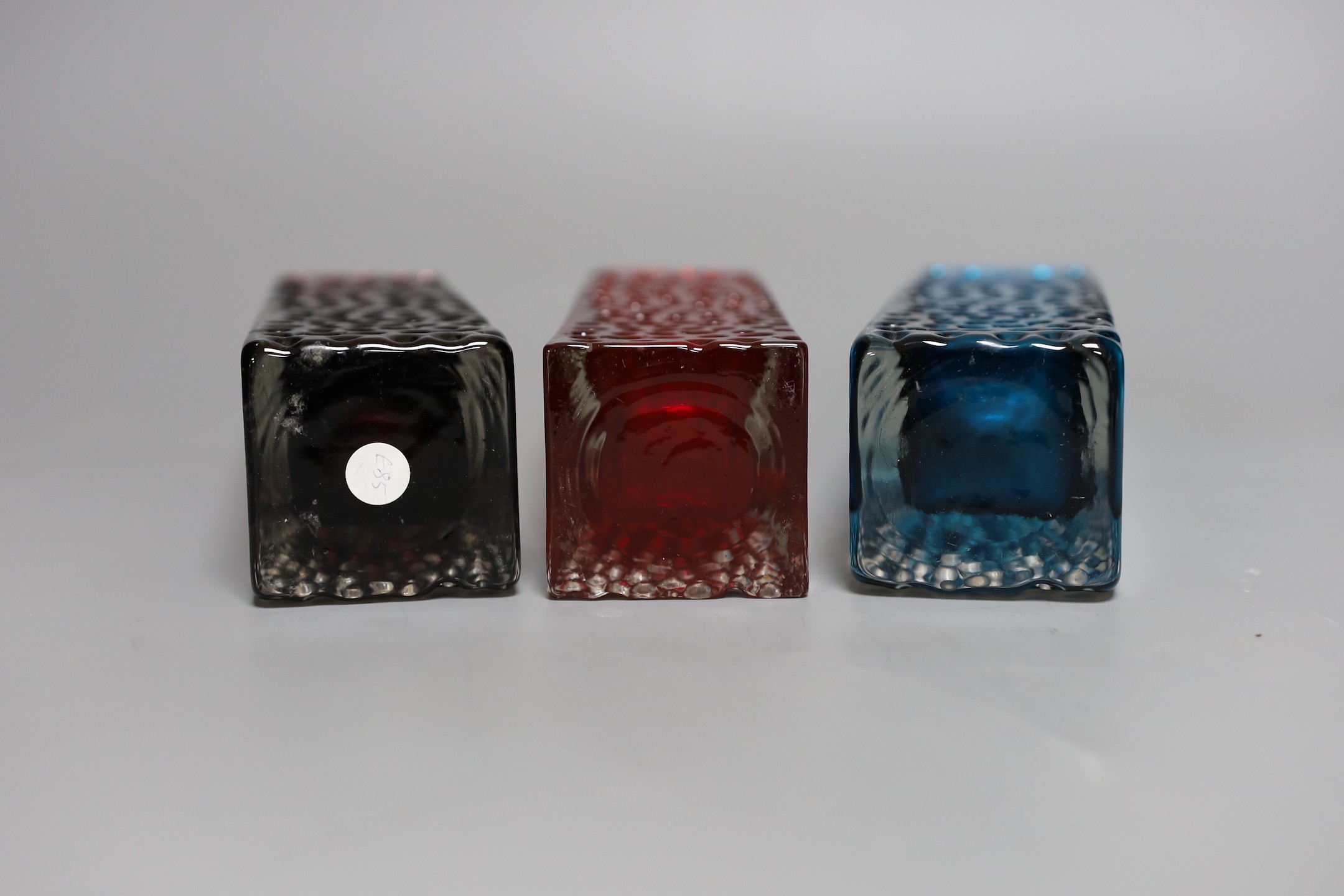 A trio of Whitefriars 'Nailhead' vases, designed by Geoffrey Baxter, kingfisher blue, red and amethyst glass, 20 cms high